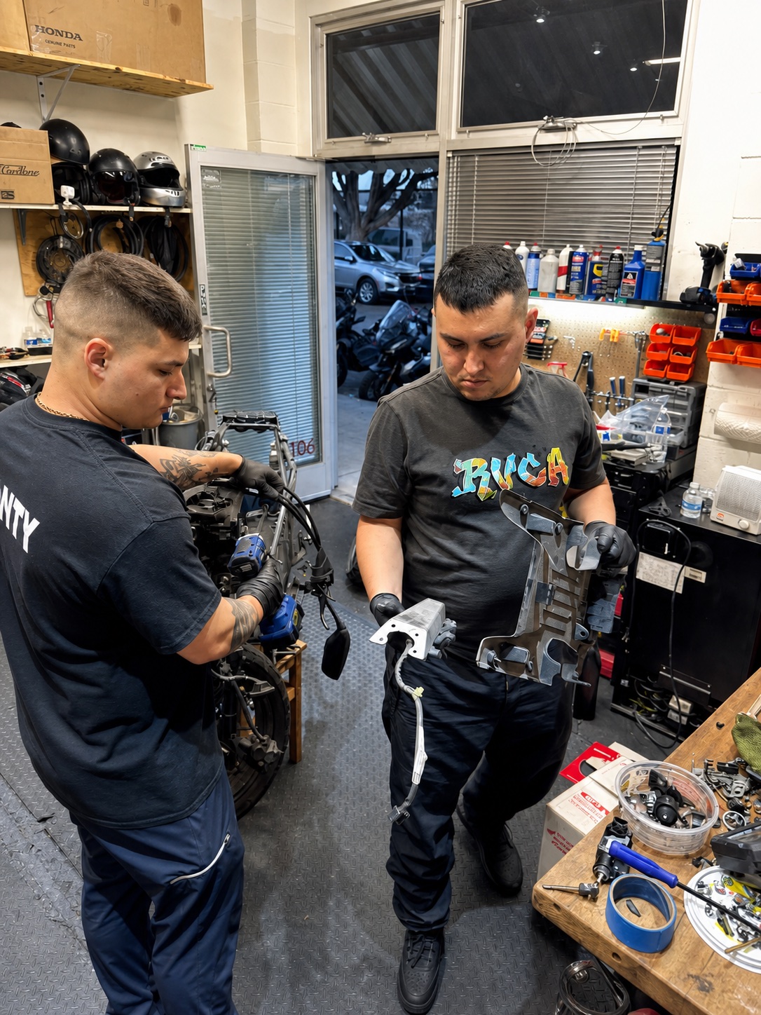 Two Real Facts mechanics working together on scooter components
