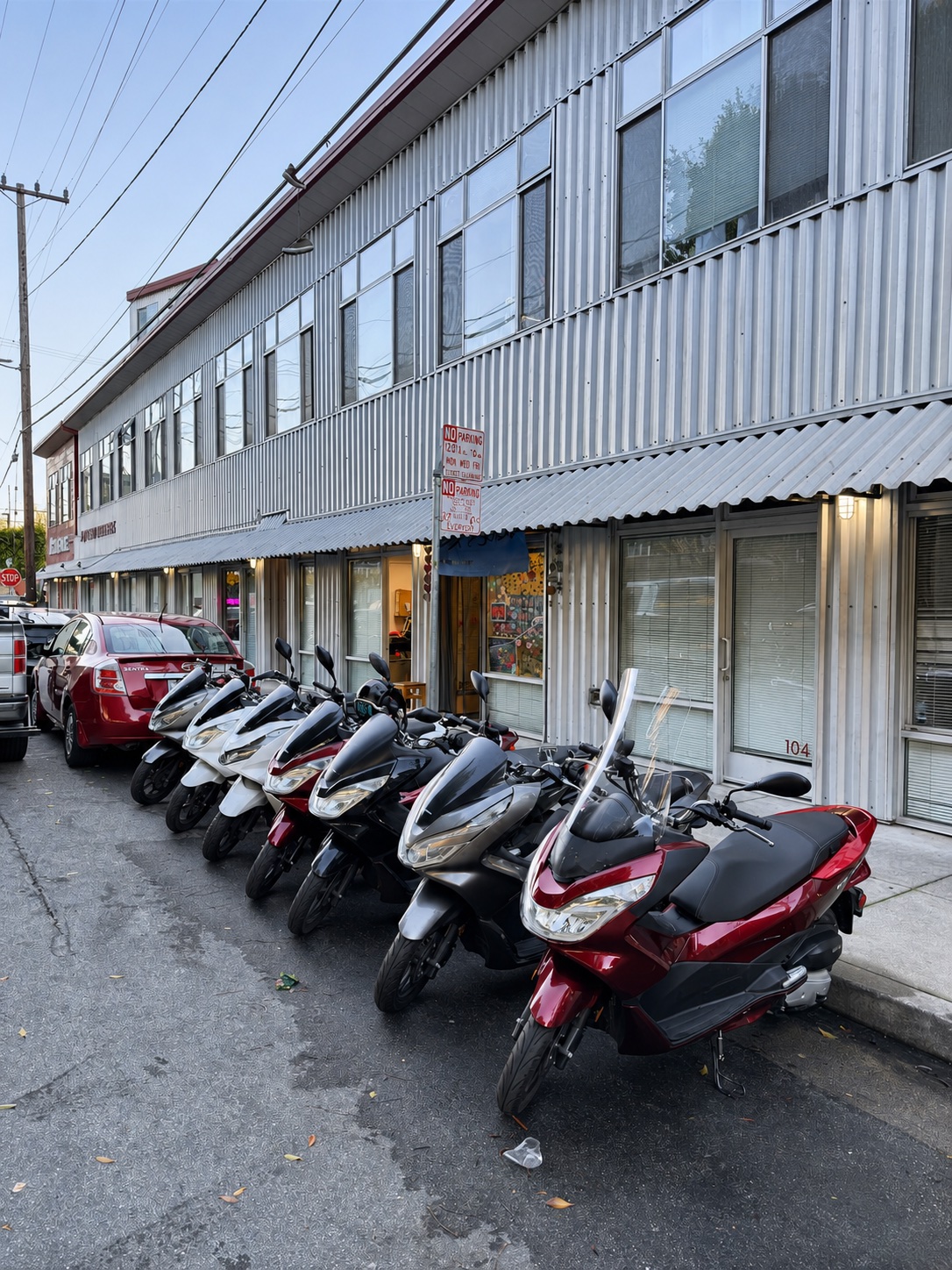 Scooters lined up along the Real Facts workshop storefront